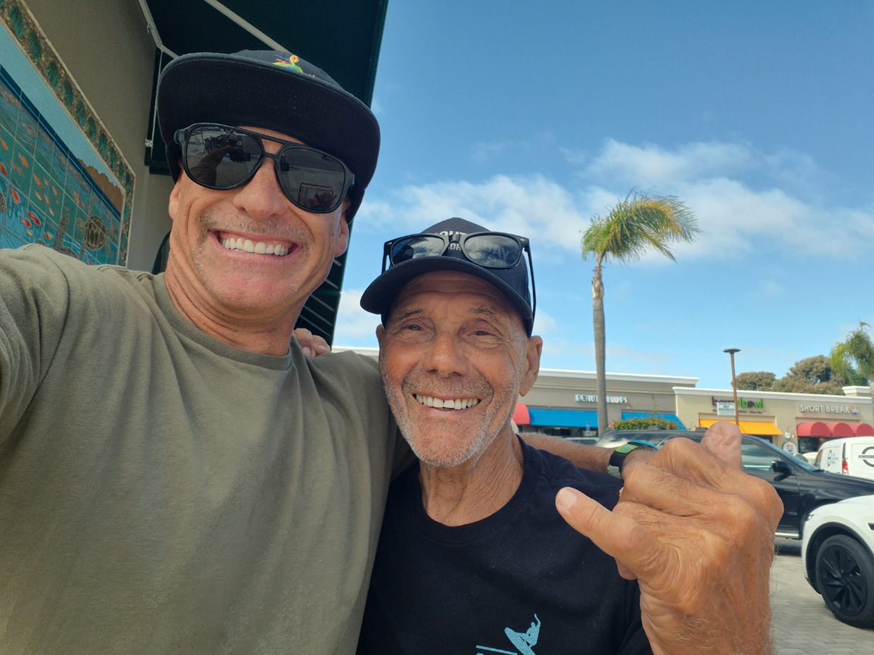 Two friends sharing a laugh and a shaka by the South Bay